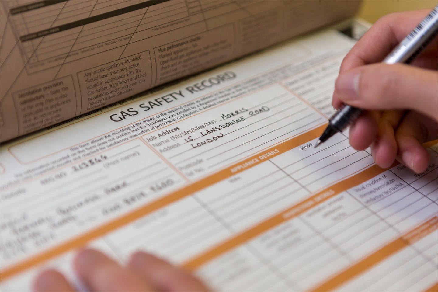 An engineer filling in a landlord gas safety record